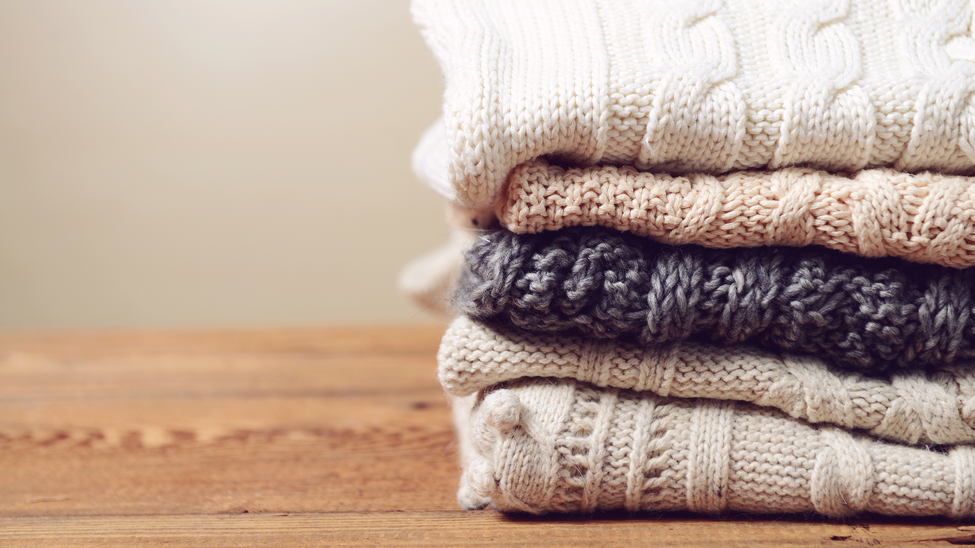 Теплые изделия. Стопка свитеров. Уютные вязаные вещи. Стопка вязаных свитеров. Шерстяные вещи.